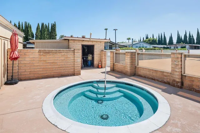 a swimming pool with outdoor seating and yard in the back