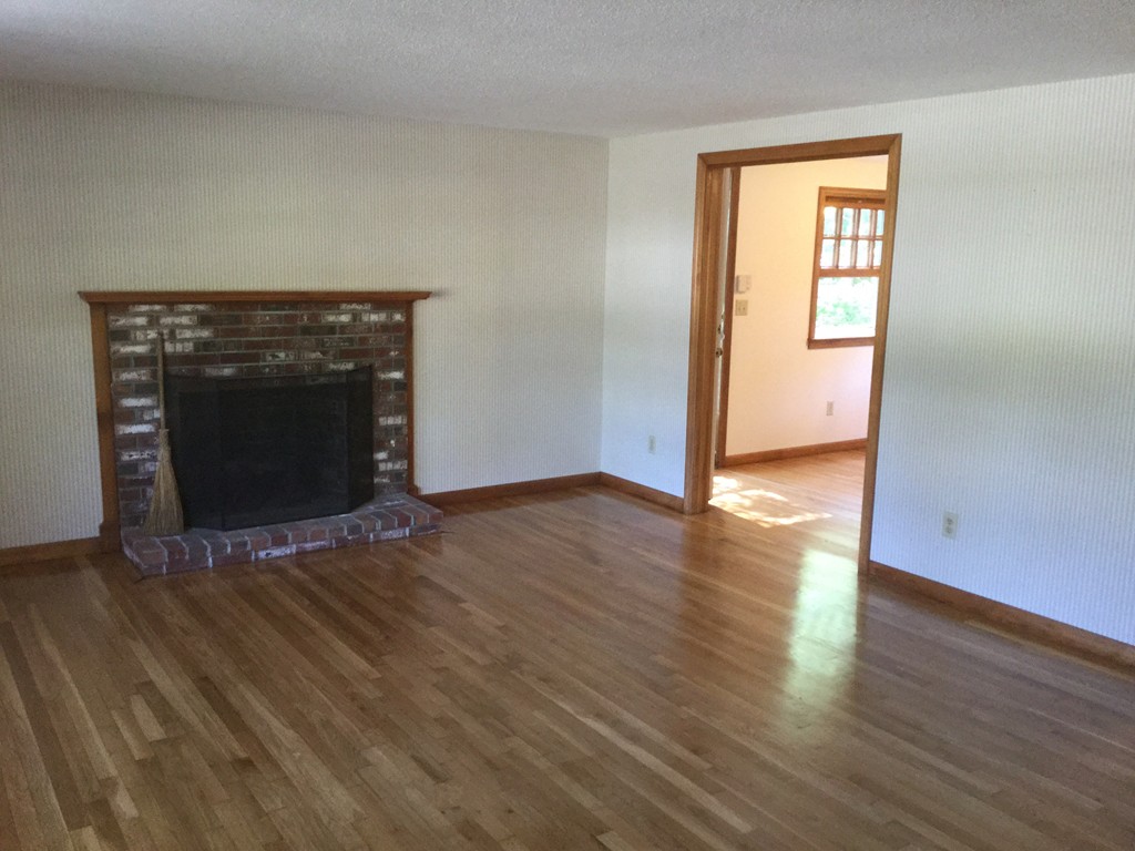 241 Megan Road Barnstable, MA 02601 - Photo 2 of 23 a view of an empty room with wooden floor and a fireplace