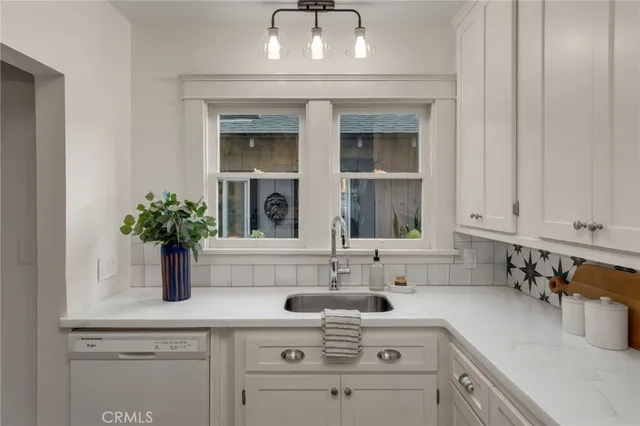 a kitchen with stainless steel appliances white cabinets and a window