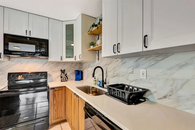 a kitchen with stainless steel appliances a sink a stove and a microwave