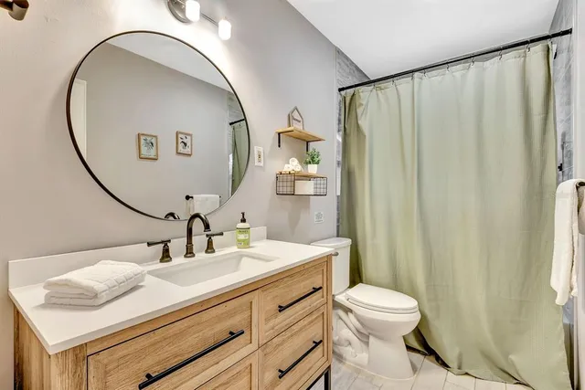 a bathroom with a sink a toilet and a mirror