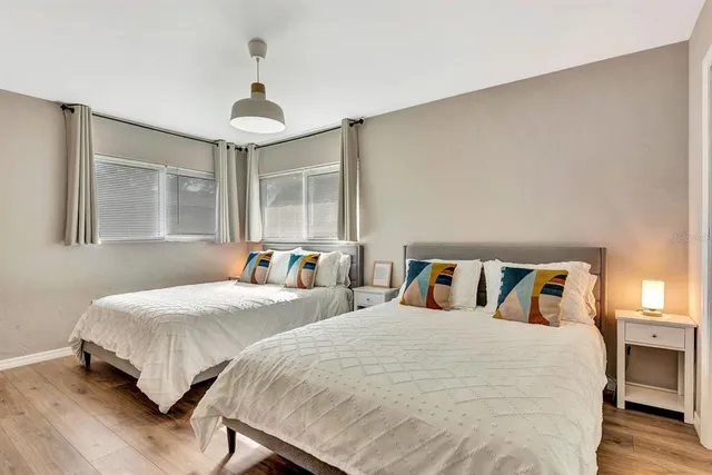 a bedroom with two beds and a chandelier