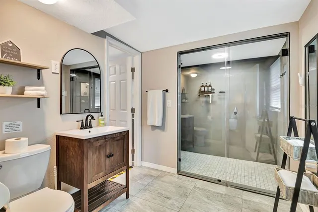 a bathroom with a sink a toilet and shower