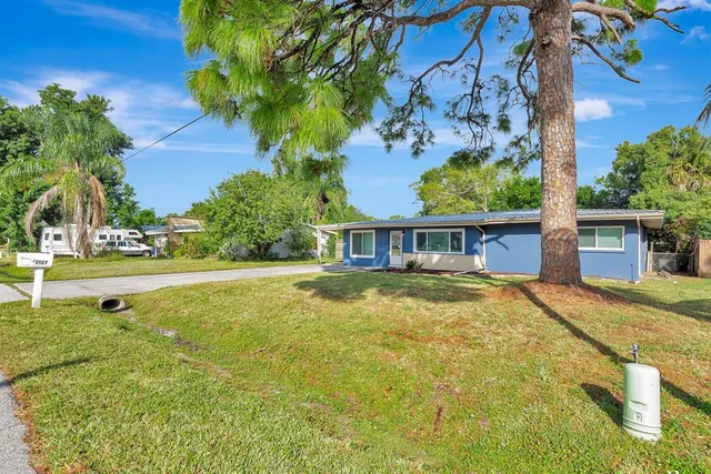 a view of a house with pool and a yard