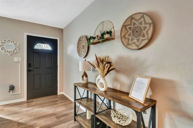 a view of a hallway with entryway and wooden floor