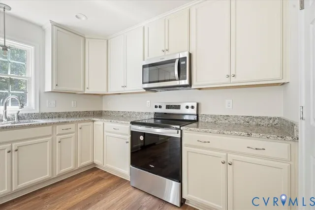 a kitchen with granite countertop white cabinets and appliances