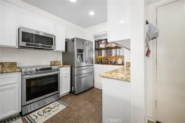a kitchen with stainless steel appliances granite countertop a refrigerator and a stove top oven