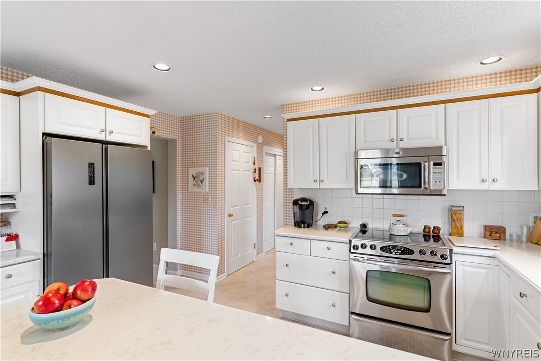 2850 Amsdell Road, Unit 34 Hamburg, NY 14075 - Photo 5 of 33 White cabinetry and stone counters define this classic, functional kitchen workspace.
