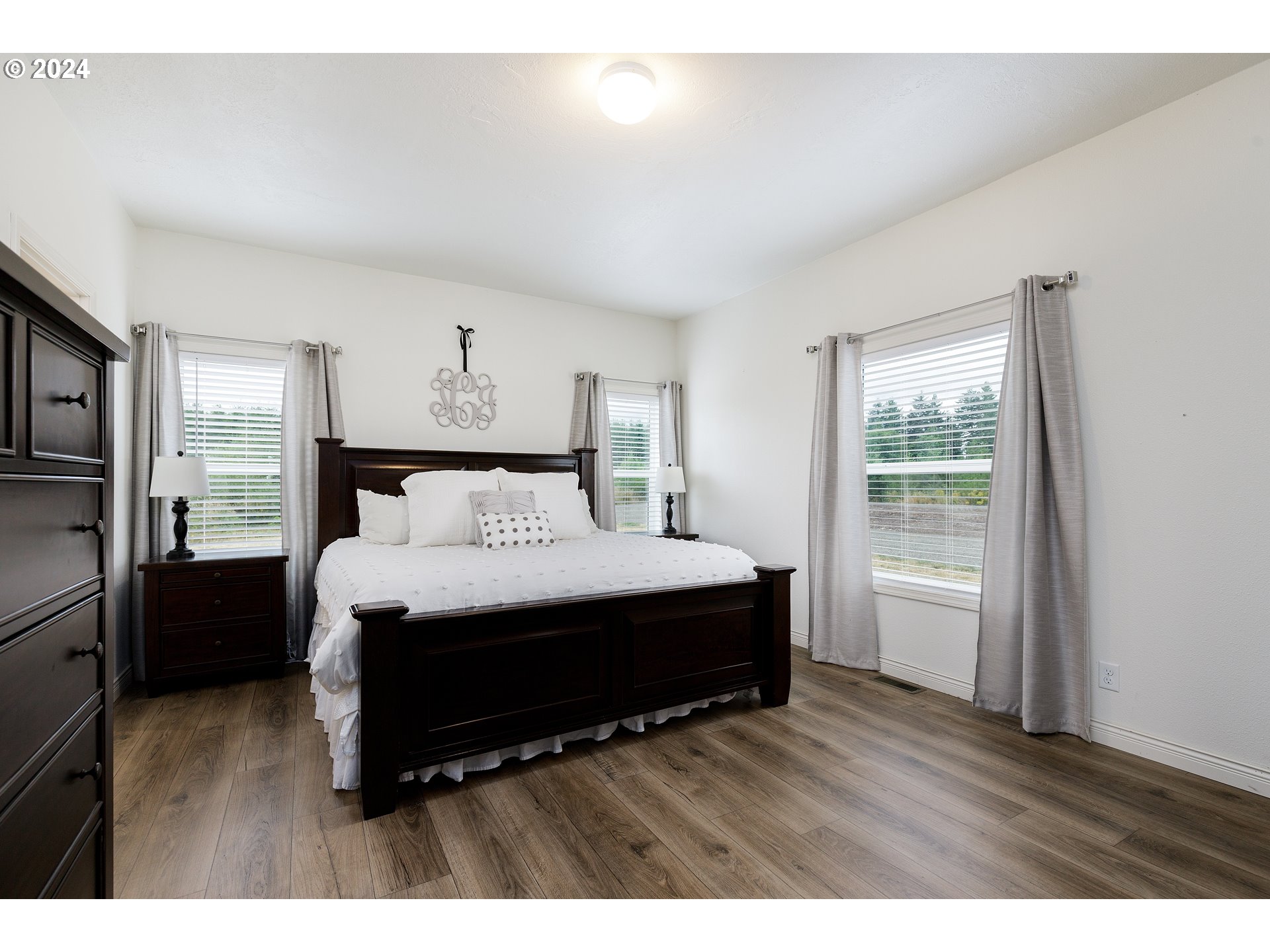 19376 Southeast Chambers Road Sandy, OR 97055 - Photo 28 of 48 a spacious bedroom with a bed and wooden floor