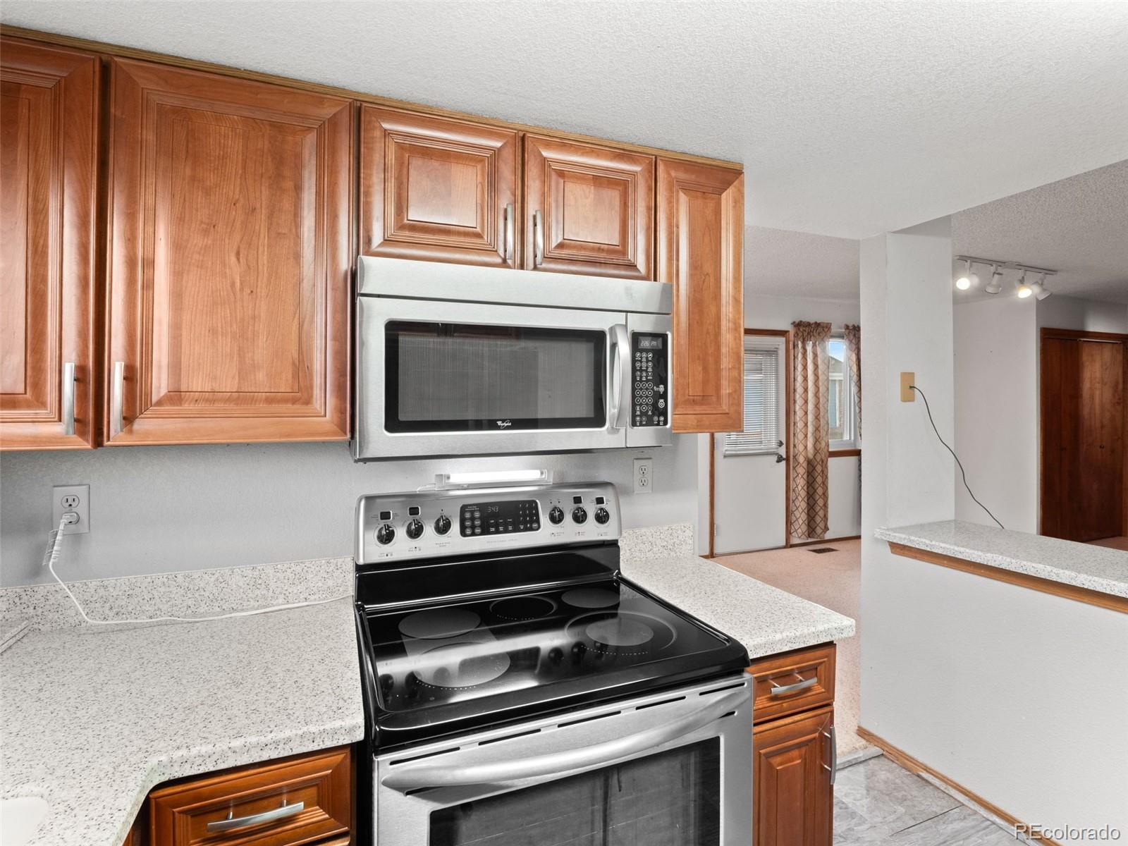 10016 Raritan Way Thornton, CO 80260 - Photo 12 of 43 a kitchen with wooden cabinets and a stove top oven