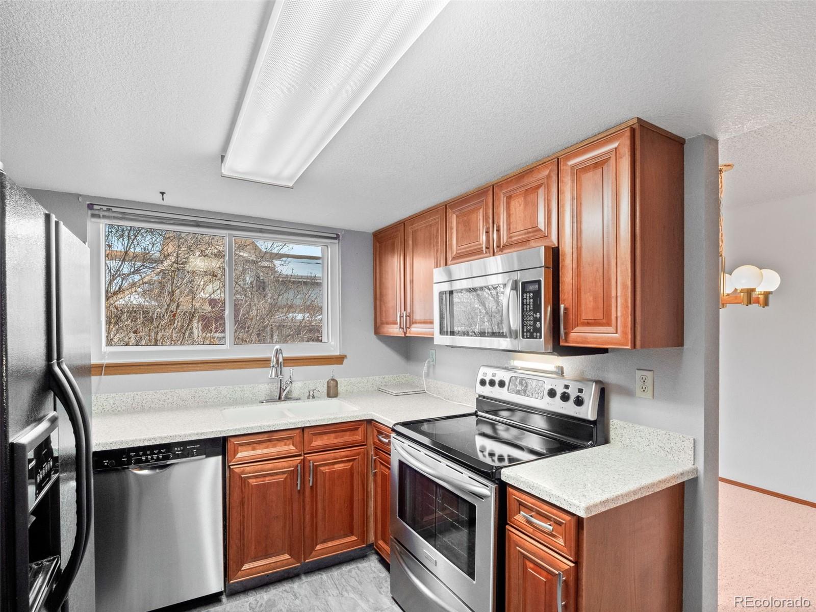 10016 Raritan Way Thornton, CO 80260 - Photo 13 of 43 a kitchen with stainless steel appliances granite countertop a sink stove and refrigerator