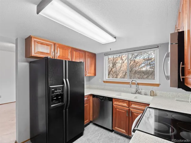 a kitchen with stainless steel appliances granite countertop a refrigerator and a sink