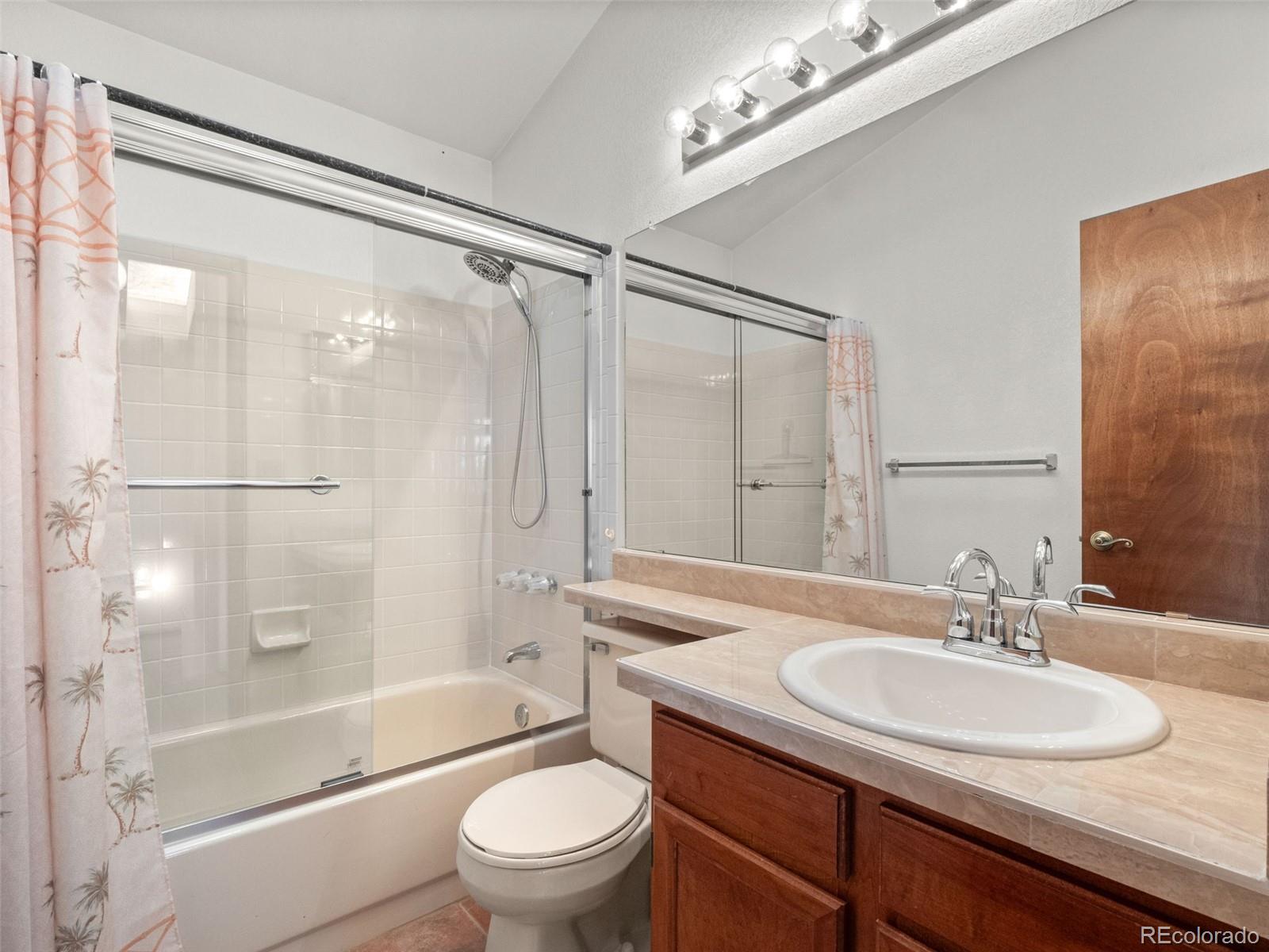 10016 Raritan Way Thornton, CO 80260 - Photo 19 of 43 a bathroom with a sink a toilet a mirror and shower