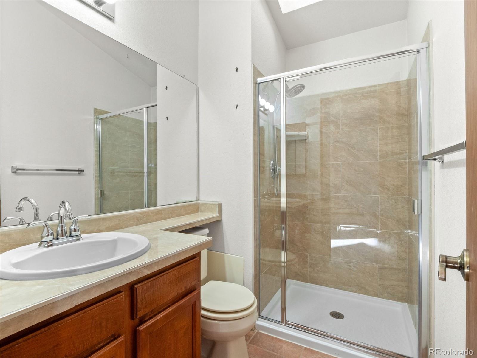 10016 Raritan Way Thornton, CO 80260 - Photo 24 of 43 a bathroom with a shower sink vanity mirror and toilet