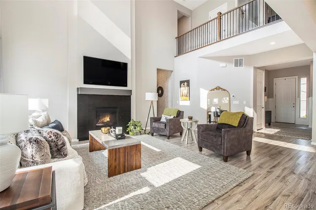 a living room with furniture a flat screen tv and a fireplace