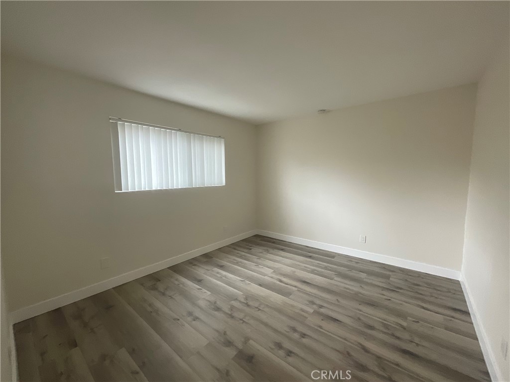 16862 Green, Unit 2 Huntington Beach, CA 92649 - Photo 10 of 13 an empty room with wooden floor and windows