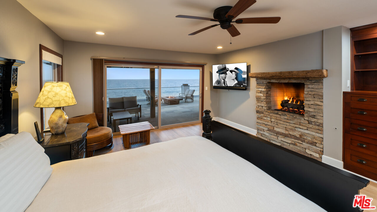 18074 Coastline Drive Malibu, CA 90265 - Photo 20 of 33 a large bedroom with a bed and wooden floor