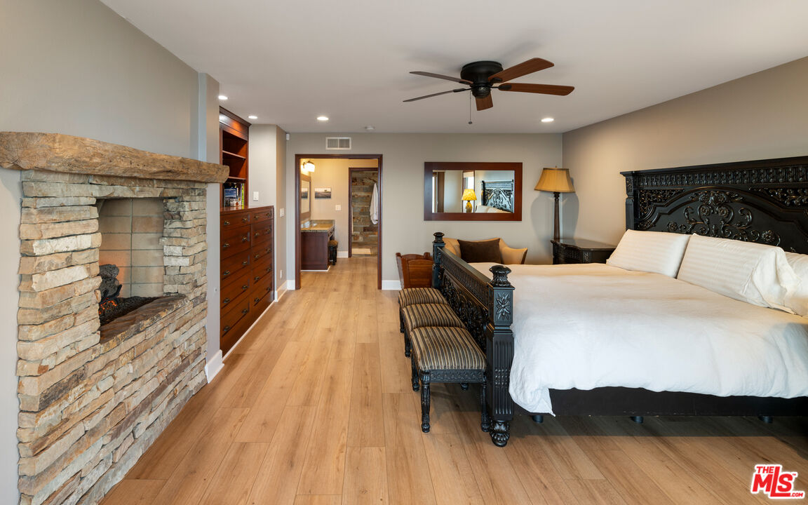 18074 Coastline Drive Malibu, CA 90265 - Photo 22 of 33 a bedroom with a bed and wooden floor