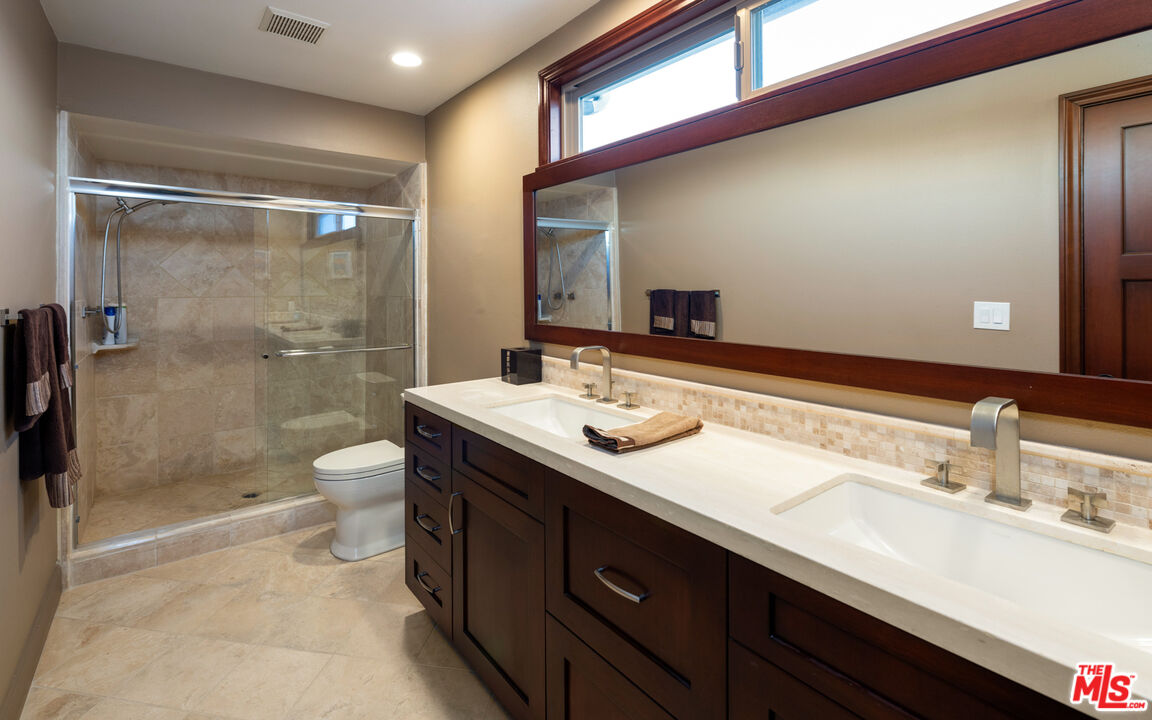 18074 Coastline Drive Malibu, CA 90265 - Photo 27 of 33 a bathroom with a sink a toilet a mirror and shower