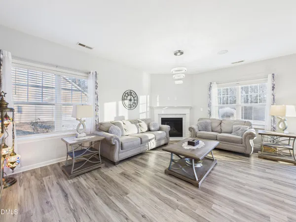 a living room with fireplace furniture and a wooden floor