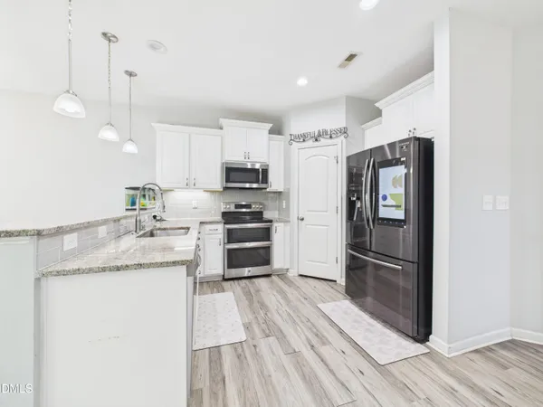 a kitchen with granite countertop a sink and steel appliances