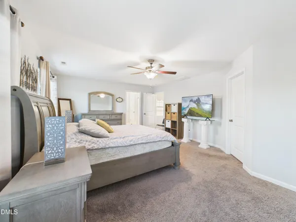 a spacious bedroom with a large bed and a chandelier