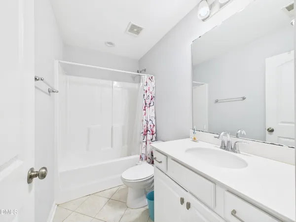 a spacious bathroom with a granite countertop sink a mirror and a bathtub