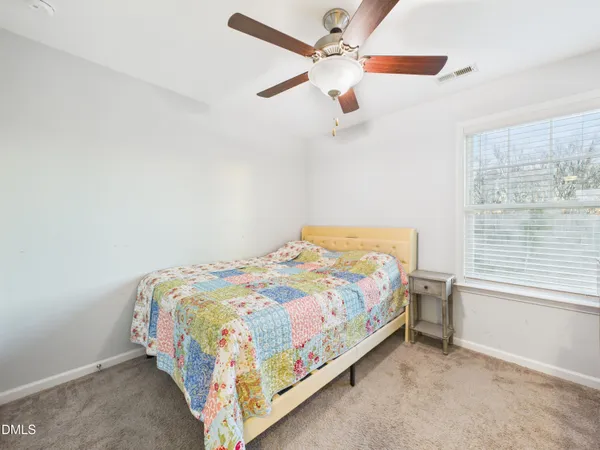 an empty room with a window and a fan