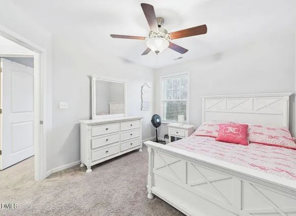 a bedroom with a bed and a ceiling fan