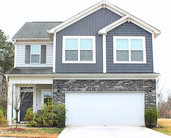 a front view of a house with a yard and a garage