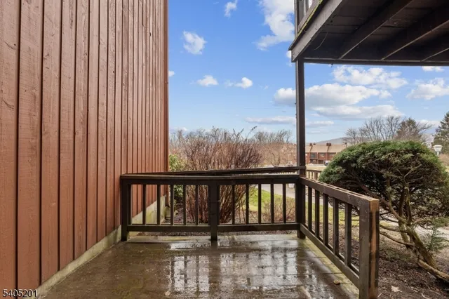 a view of a balcony with a floor to ceiling window and wooden fence