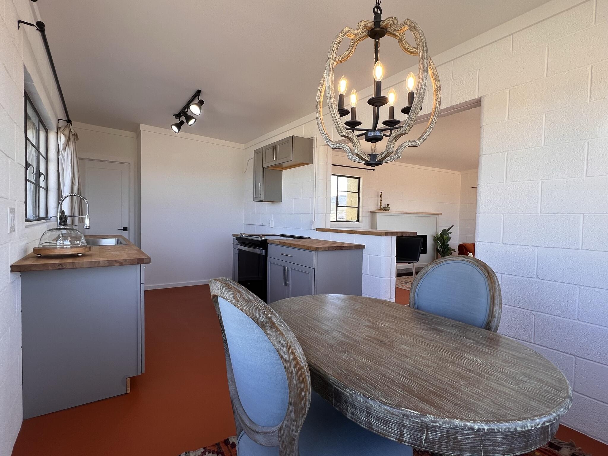 52079 Ocotillo Road Johnson Valley, CA 92285 - Photo 28 of 51 a dining room with wooden floor a chandelier a wooden table and chairs