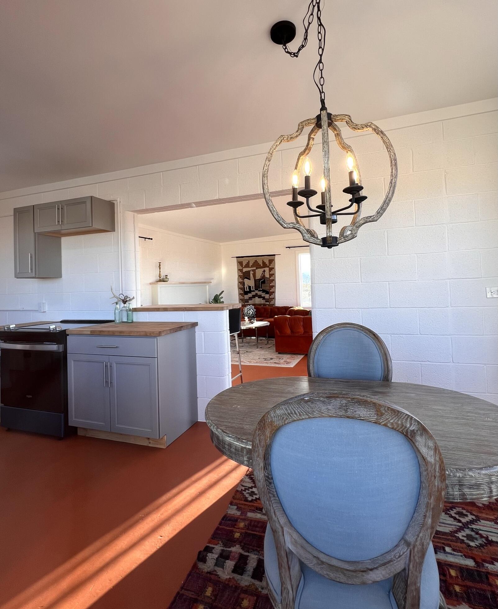 52079 Ocotillo Road Johnson Valley, CA 92285 - Photo 35 of 51 a kitchen with stainless steel appliances granite countertop a sink a stove a dining table and chairs with wooden floor