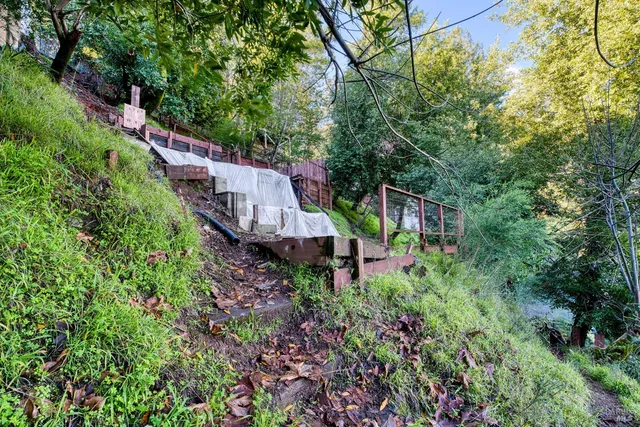 a view of a house with a yard and wooden fence