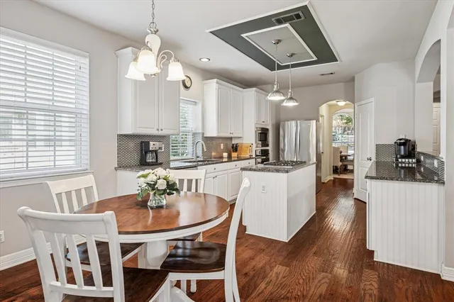 a kitchen with a dining table chairs and view of living room