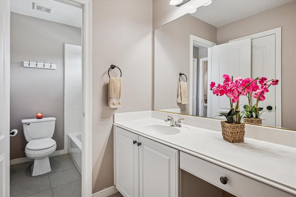 7509 Cedar Elm Drive Irving, TX 75063 - Photo 23 of 40 a bathroom with a sink a toilet and a mirror