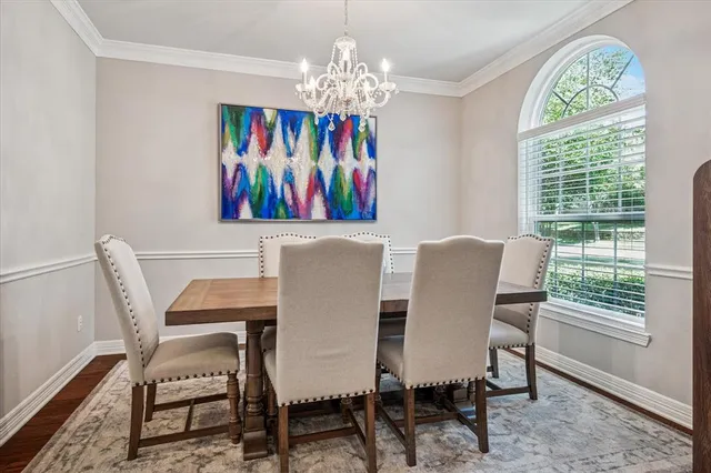 a view of a dining room with furniture a chandelier and a window
