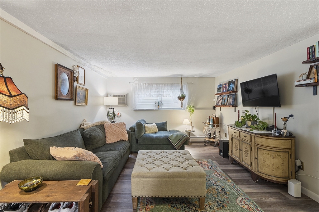 349 Hildreth Street, Unit 16 Lowell, MA 01850 - Photo 2 of 8 a living room with furniture and a flat screen tv
