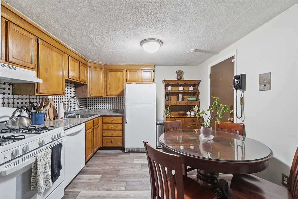 349 Hildreth Street, Unit 16 Lowell, MA 01850 - Photo 5 of 8 a kitchen with stainless steel appliances granite countertop a sink a stove and refrigerator