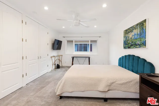 a bedroom with a bed a mirror and a window