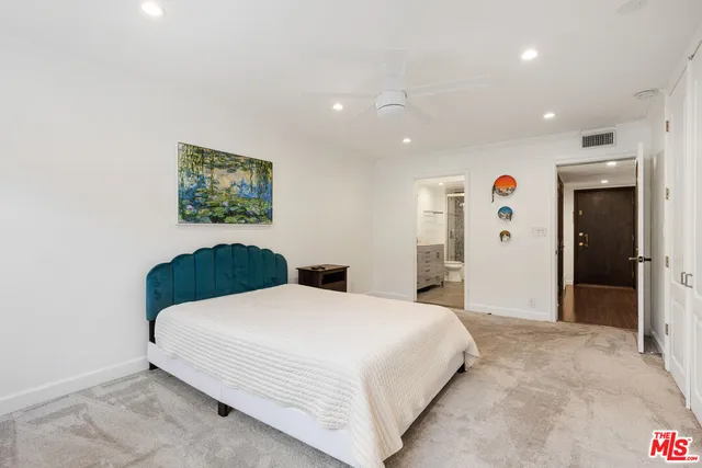 a bedroom with a large bed and a painting