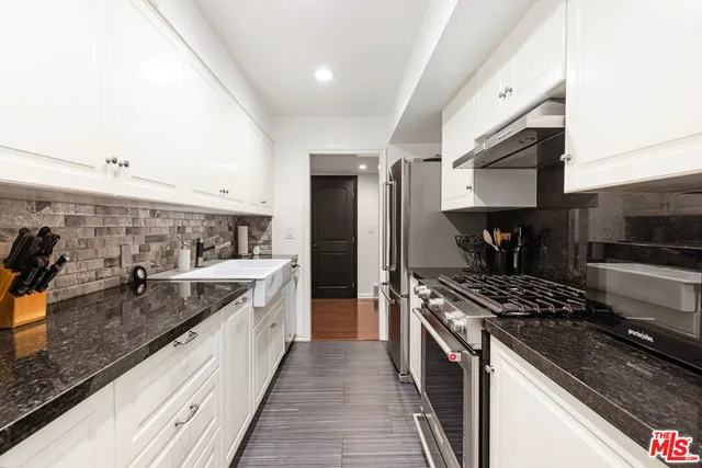 a kitchen with stainless steel appliances granite countertop a sink and stove