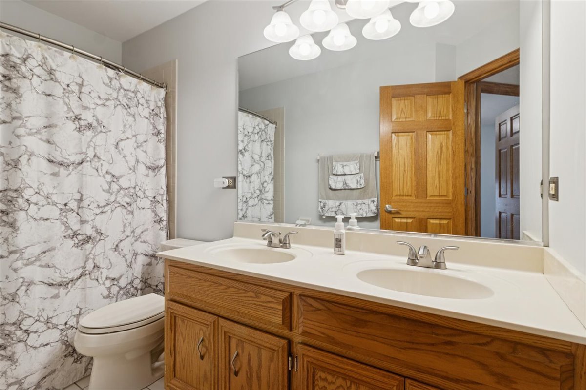 818 Wescott Road Bolingbrook, IL 60440 - Photo 24 of 33 a bathroom with a sink a toilet and a mirror