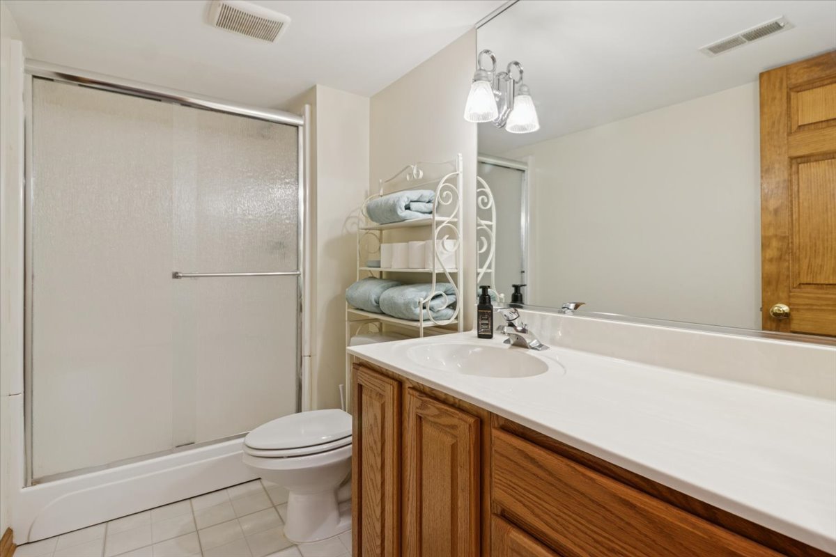 818 Wescott Road Bolingbrook, IL 60440 - Photo 31 of 33 a bathroom with a sink a toilet a mirror and shower