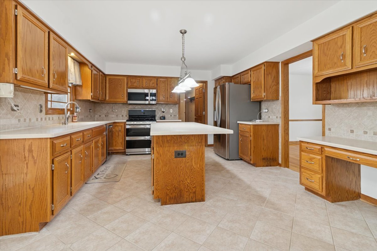 818 Wescott Road Bolingbrook, IL 60440 - Photo 10 of 33 a kitchen with stainless steel appliances granite countertop a sink counter space cabinets a stove and a window