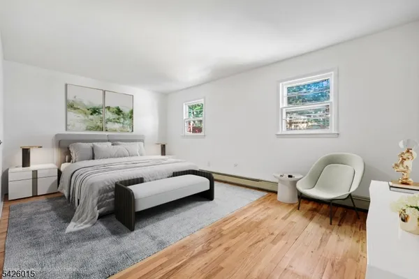 a spacious bedroom with a bed a couch and paintings on the wall
