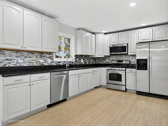 a kitchen with appliances a sink and cabinets