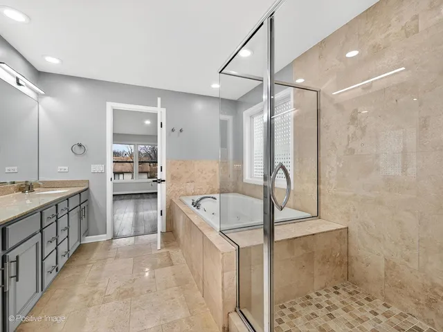 a large bathroom with a tub a sink shower and mirror