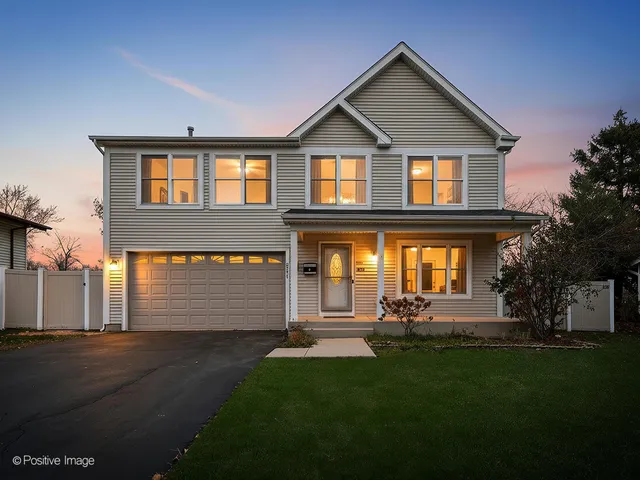 a front view of a house with a garden and plants