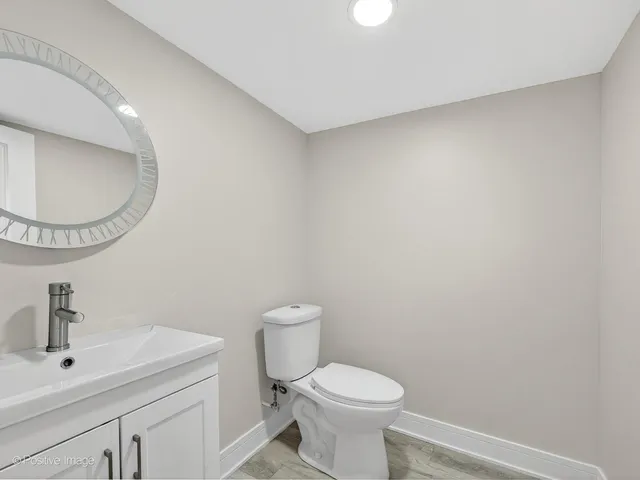 a bathroom with a toilet a sink and mirror